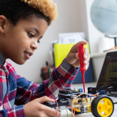 Hands-On Activities Male Elementary School Pupil Building Robot Car In Science Lesson